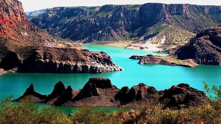 Dique valle Grande com águas em tons verde-esmeralda cercado por montanhas, destino icônico de enoturismo próximo às vinícolas de San Rafael.